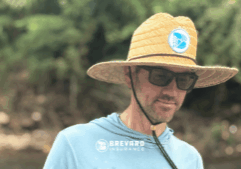 man in a hat by a river